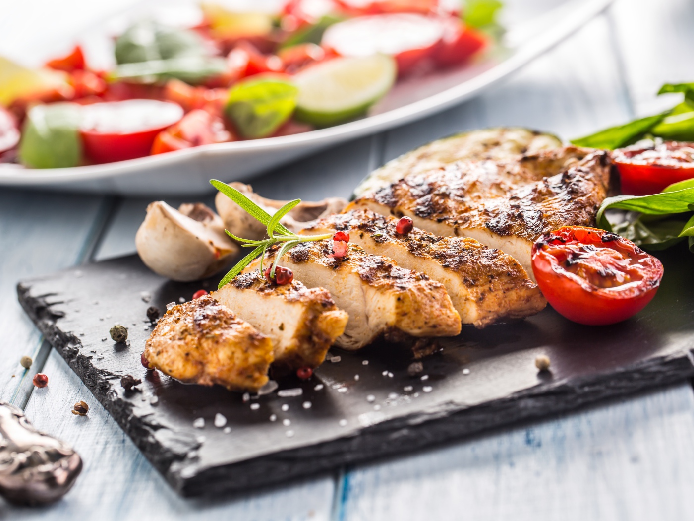 Запеченное куриное мясо на доске с помидорами 