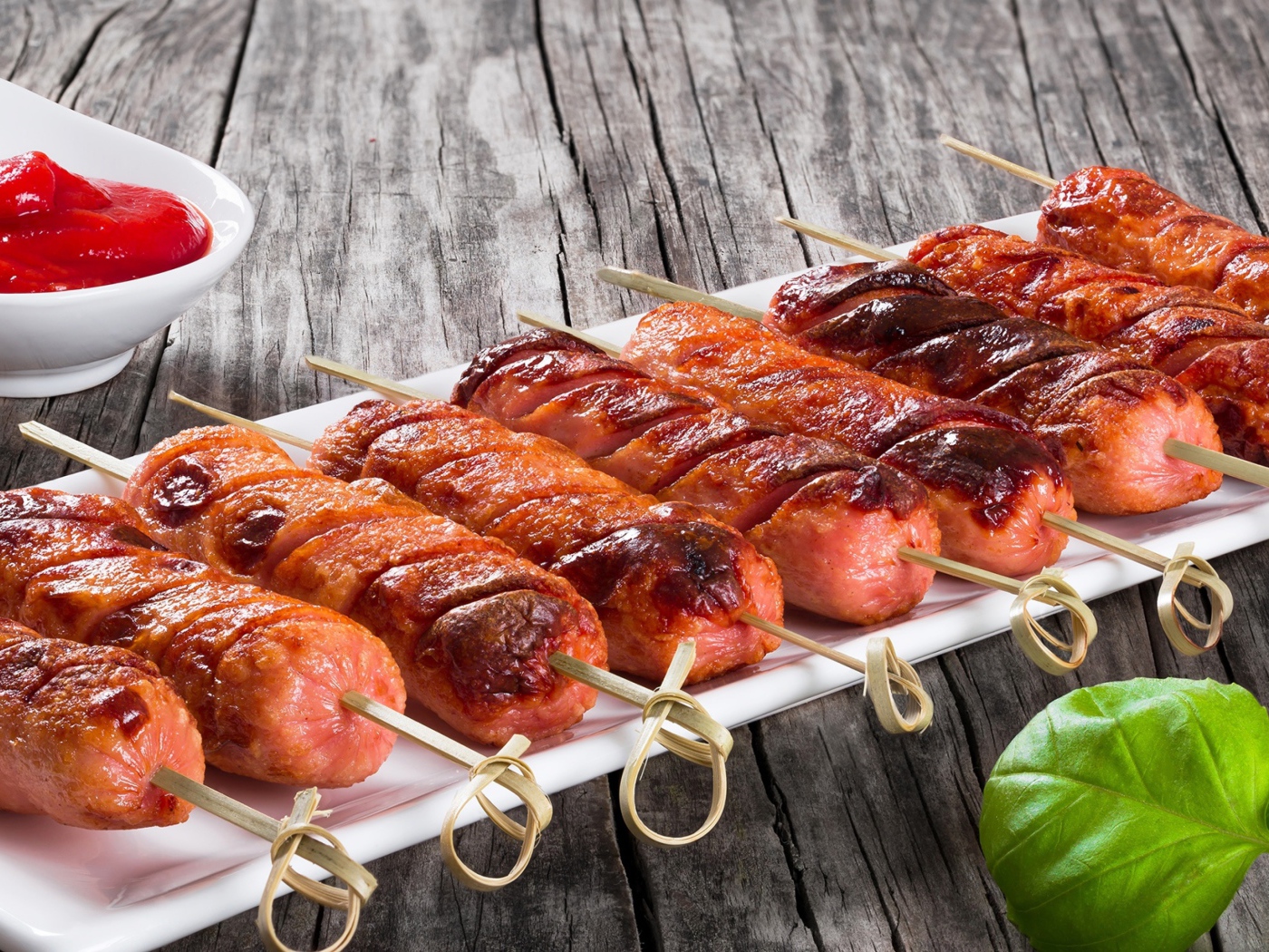 Сосиски гриль на шпажках на столе с соусом