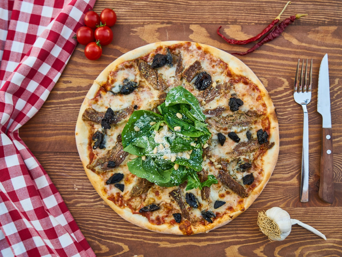 Пицца с мясом и шпинатом на столе 