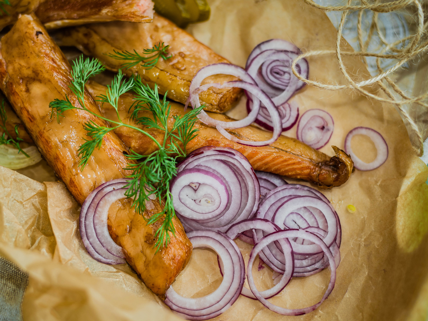 Копченое филе рыбы на бумаге с луком