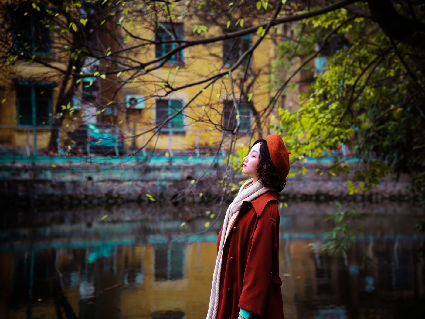Девушка азиатка в красном пальто у воды
