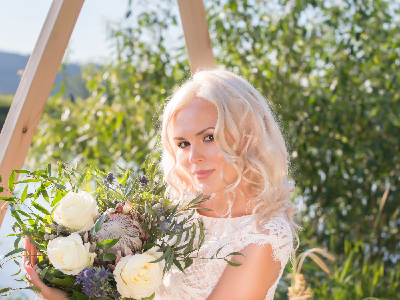 Красивая кареглазая блондинка с букетом в руках 