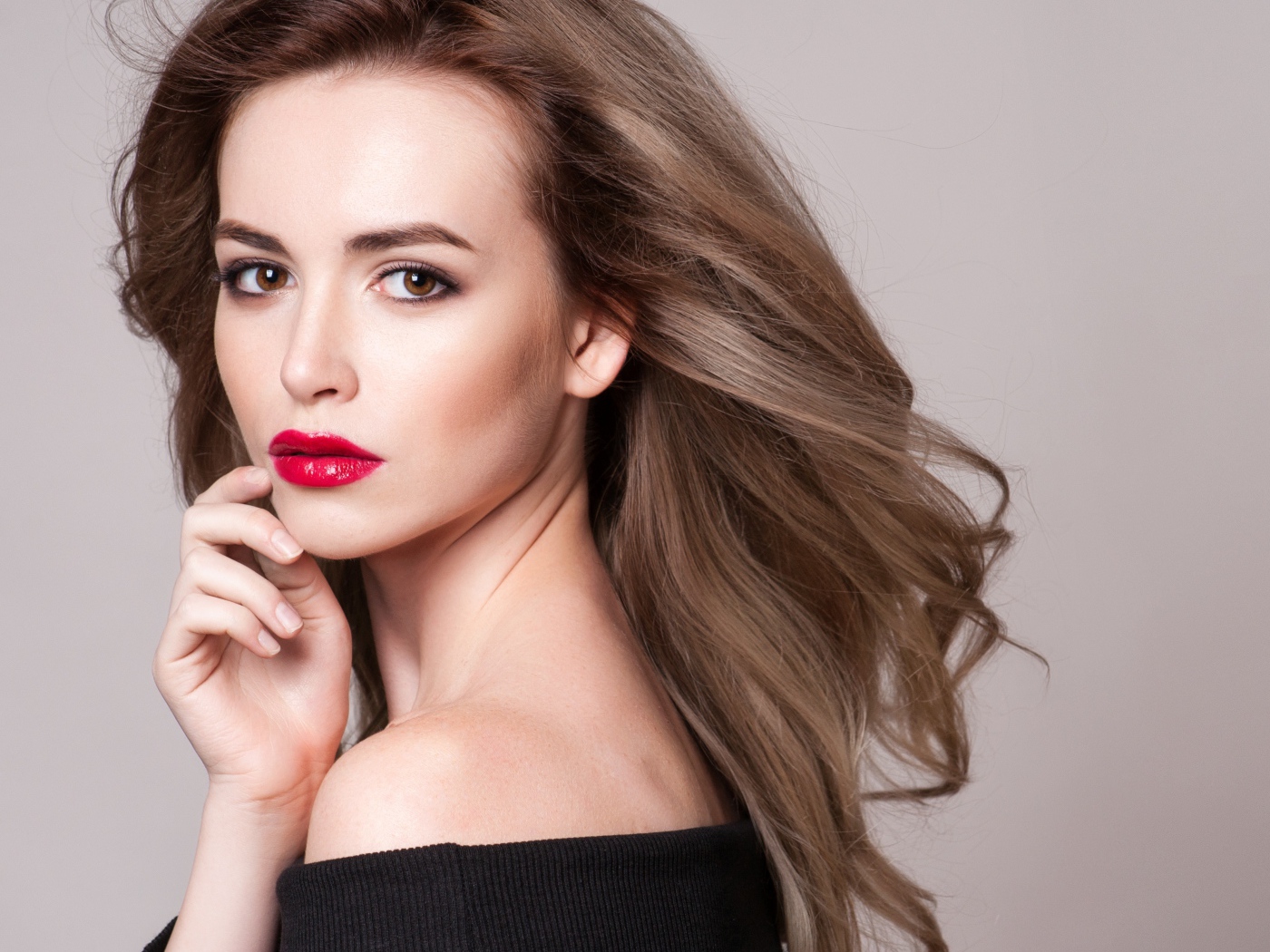 Красивая шатенка с красными губами на сером фоне