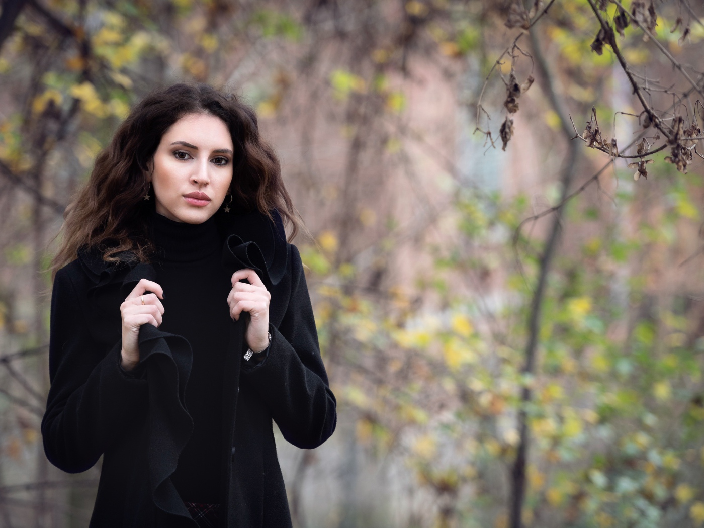 Красивая девушка в черном пальто осенью