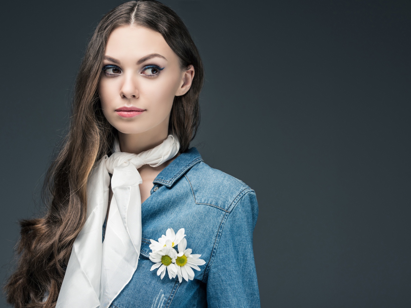 Красивая девушка в джинсовой куртке с шарфом на шее 