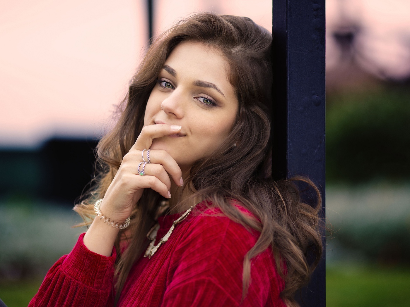 Красивая длинноволосая шатенка с рукой у лица