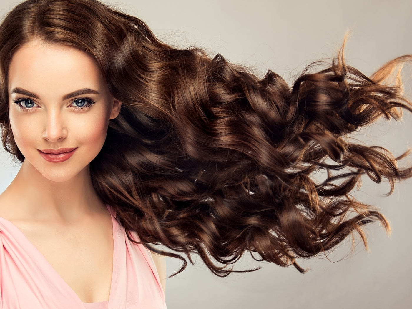 Красивые длинные волосы у девушки на сером фоне