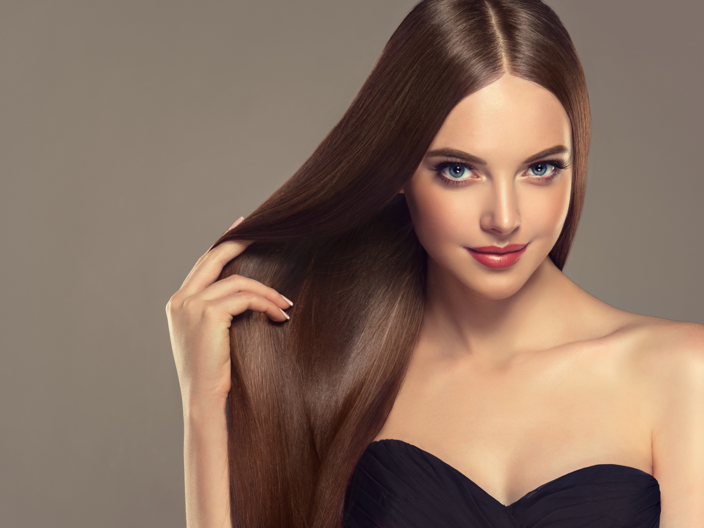 Красивая нежная длинноволосая голубоглазая девушка на сером фоне