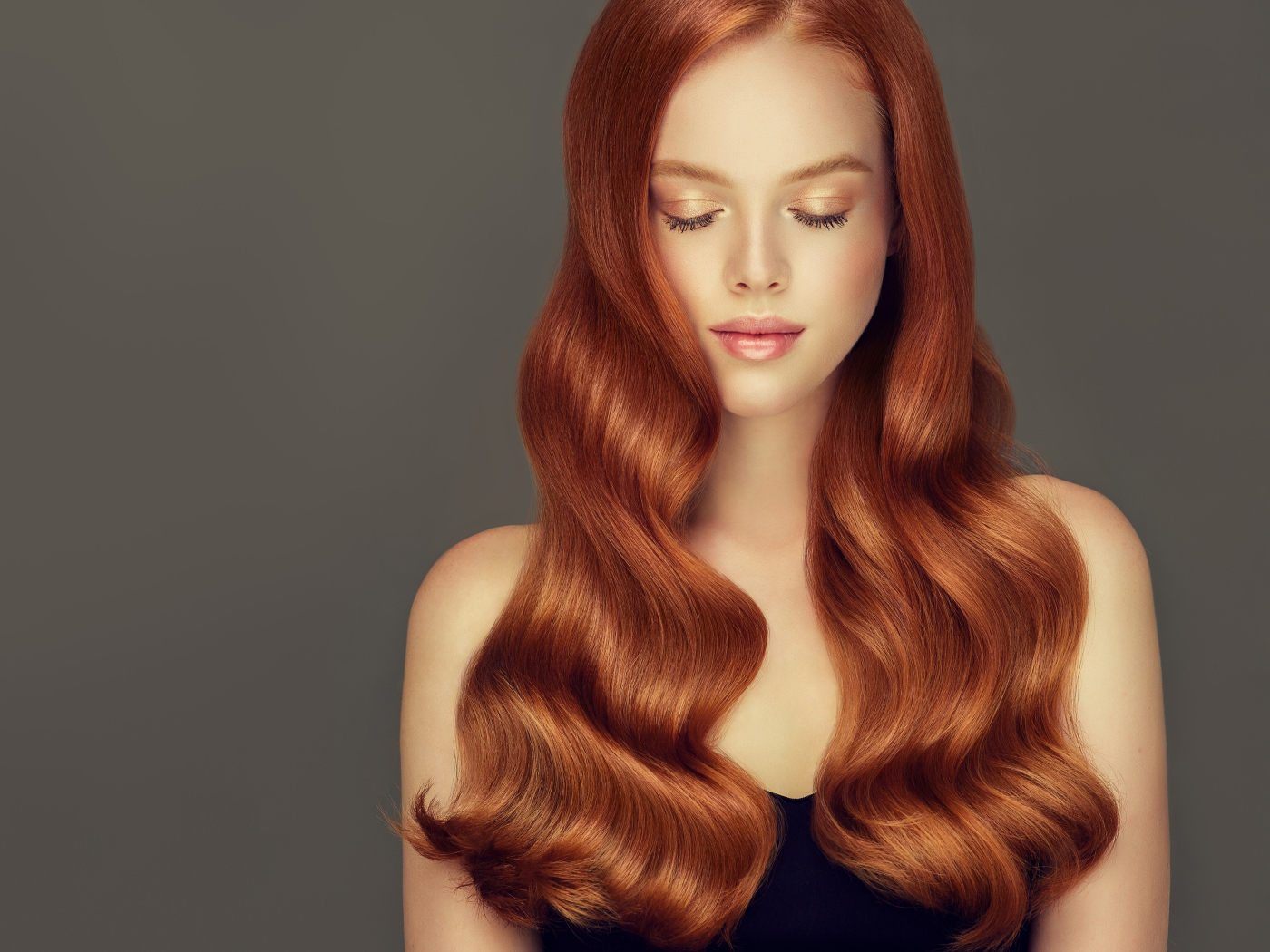 Красивая нежная рыжеволосая девушка на сером фоне