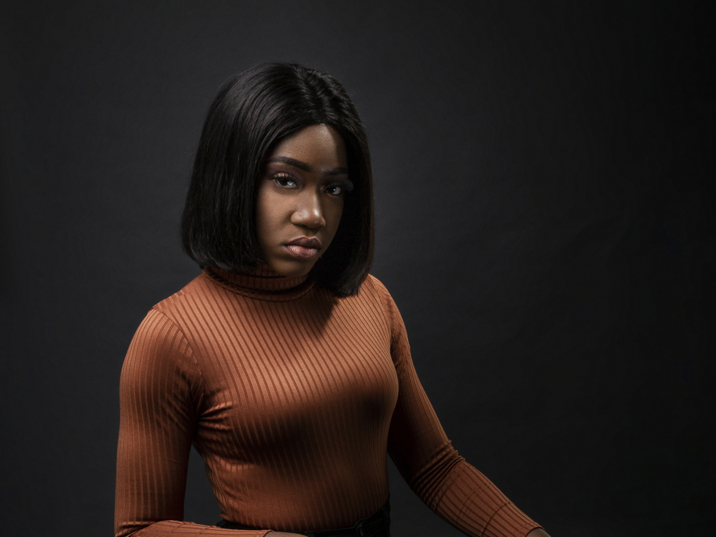 Темнокожая девушка с короткой стрижкой на сером фоне