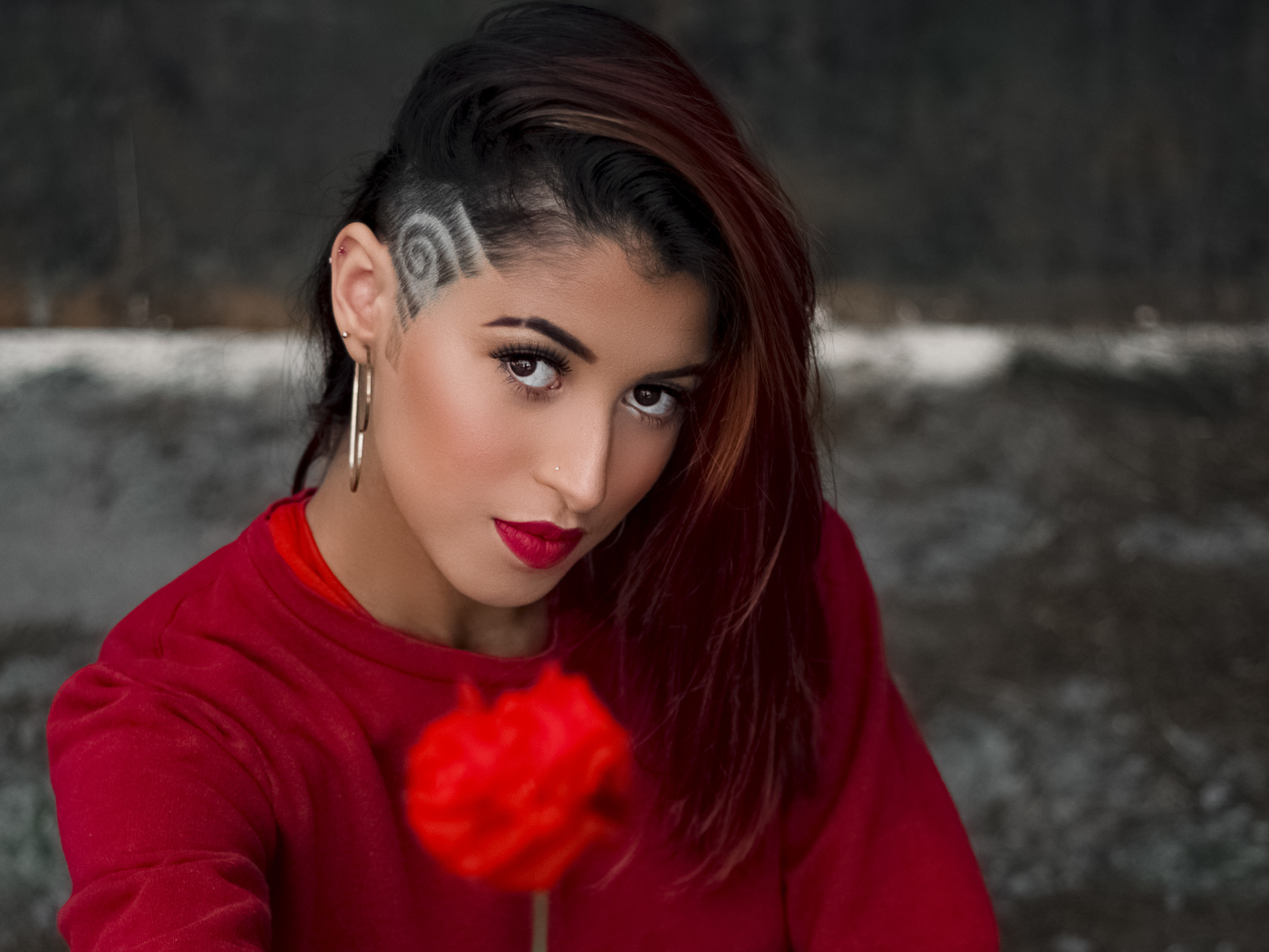 Девушка со стрижкой держит розу в руке