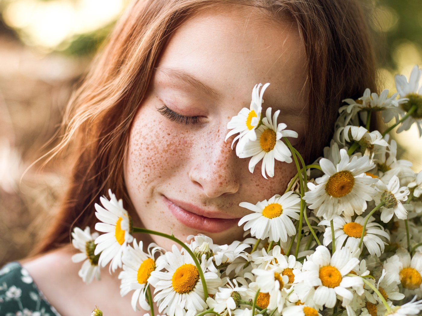 Рыжеволосая девушка с букетом ромашек