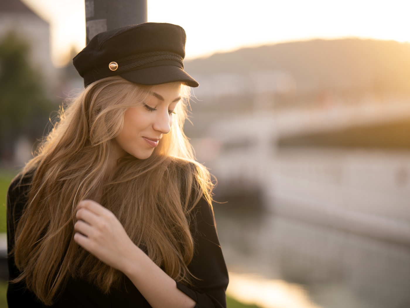 Нежная девушка в черной кепке в лучах солнца