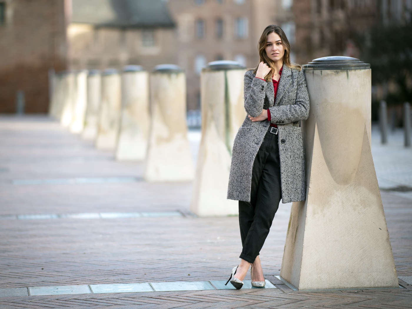 Девушка стоит в сером пальто 