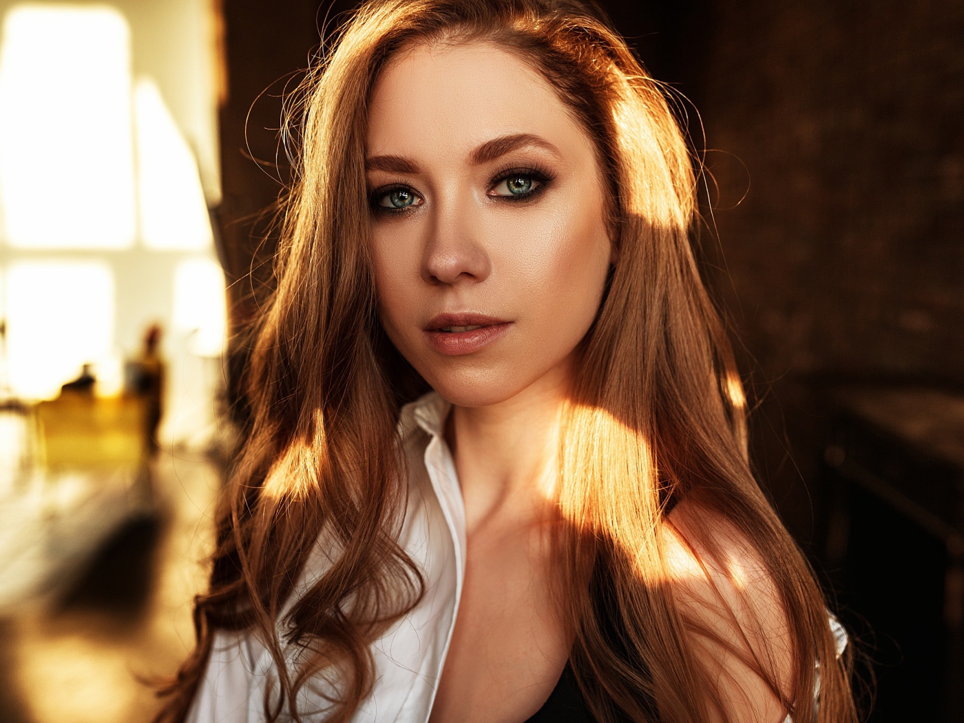 Лучи солнца нападают на волосы голубоглазой шатенки 