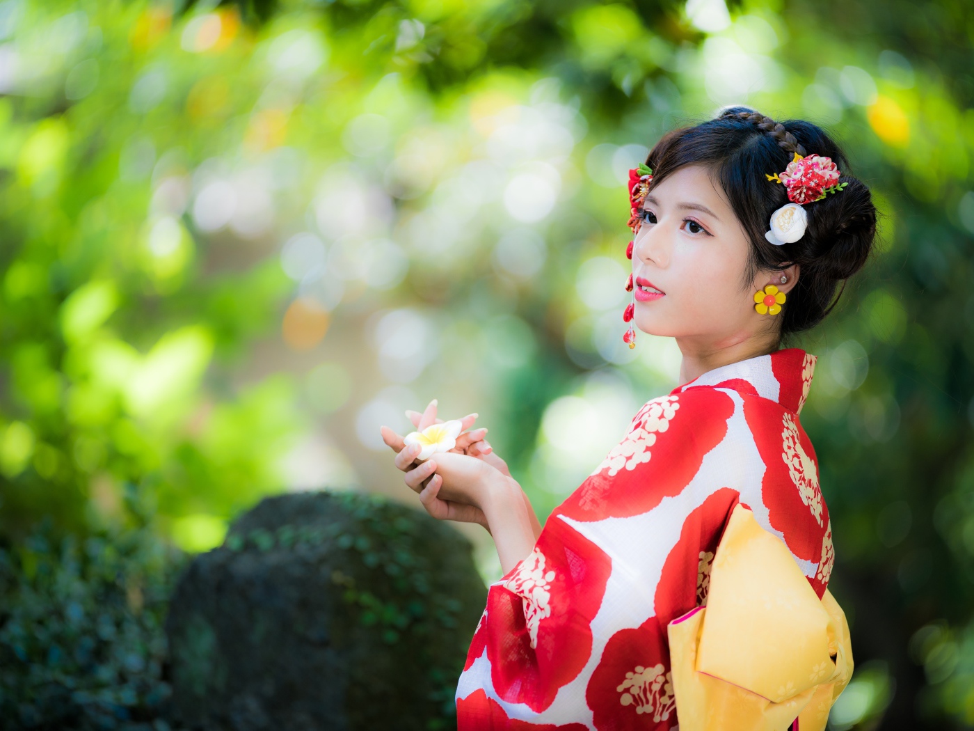 Молодая девушка азиатка в кимоно с цветами в волосах 
