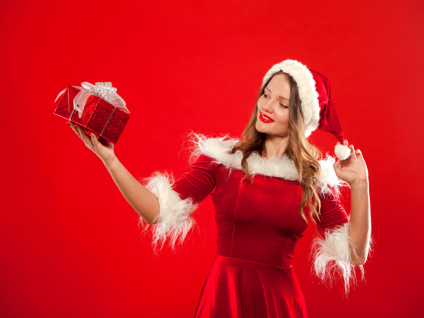 Beautiful Snow Maiden with a gift in her hand on a red background
