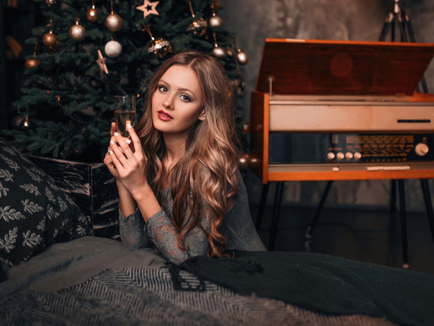 Красивая девушка с фужером шампанского у новогодней елки