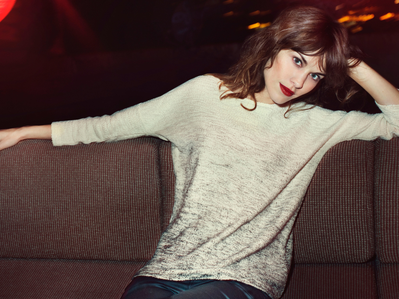 Красивая девушка модель Алекса Чанг сидит на диване