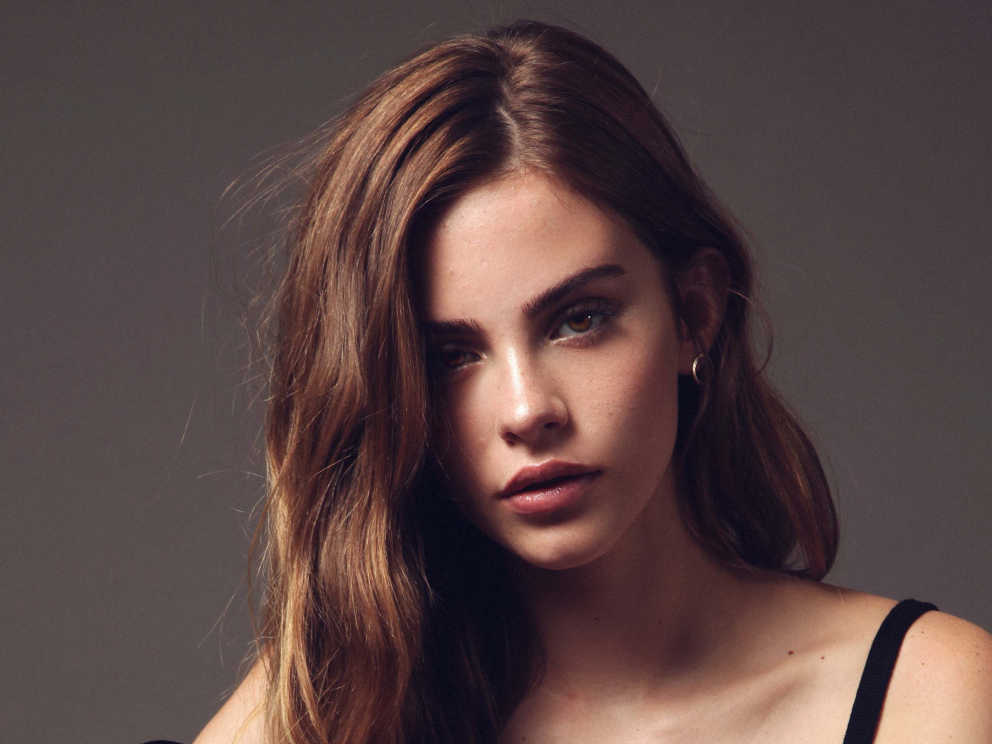 Красивая молодая девушка модель Бриджет Саттерли на сером фоне