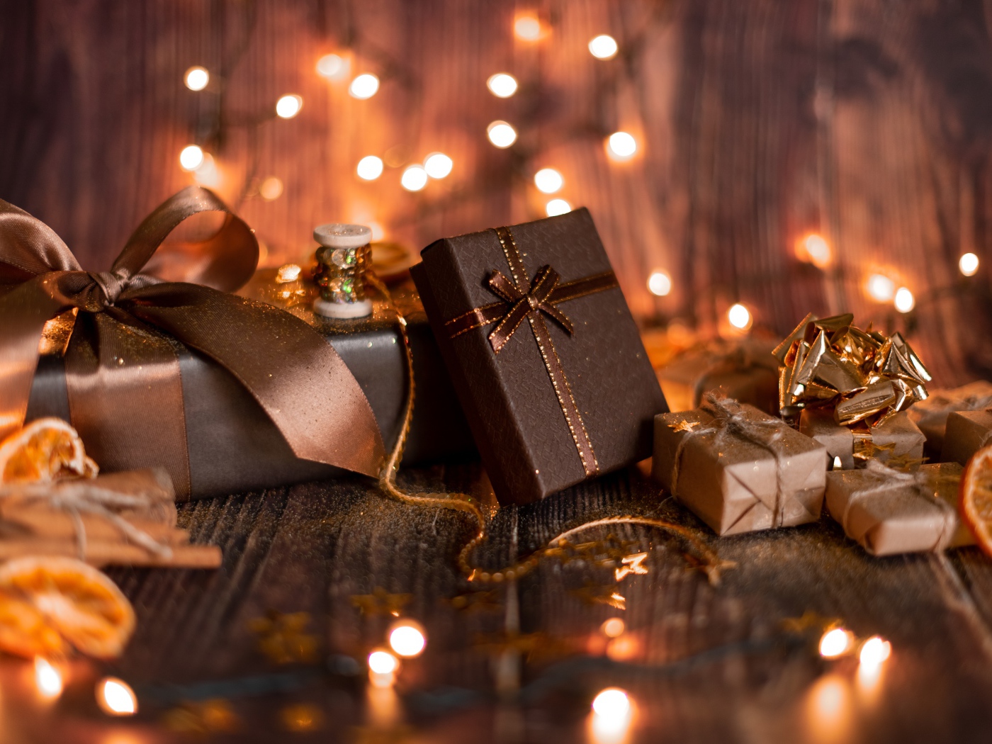 Много подарков на деревянном фоне с гирляндой