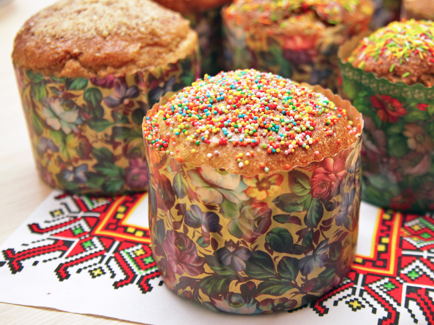 Вкусные сладкие куличи с посыпкой стоят на рушнике