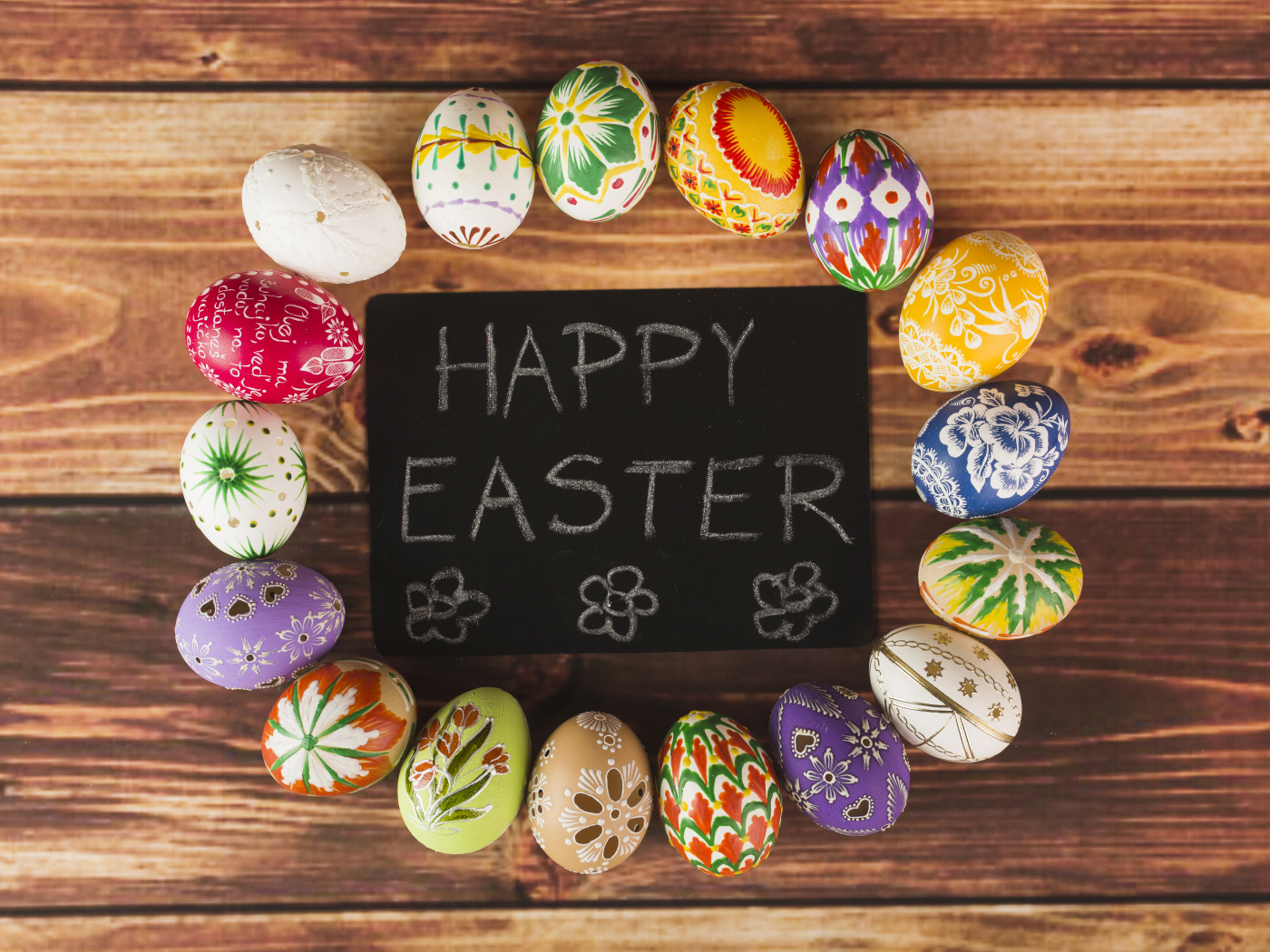 Надпись на английском Счастливой Пасхи на столе с крашеными яйцами