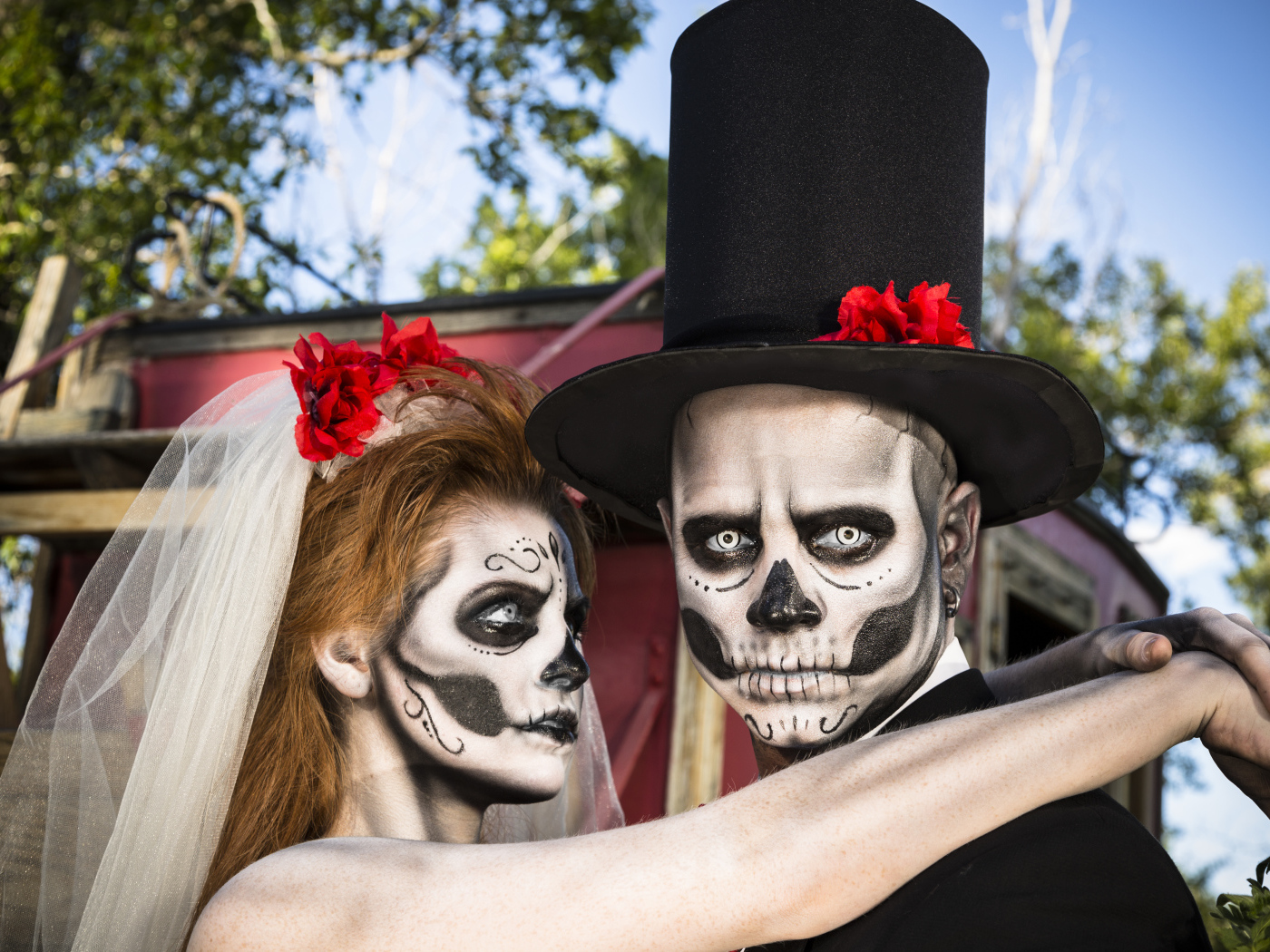Пара жених и невеста с масками с грима на лице на Хэллоуин 