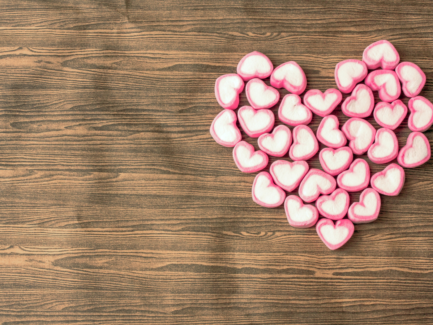 Сердце из конфет на деревянном столе