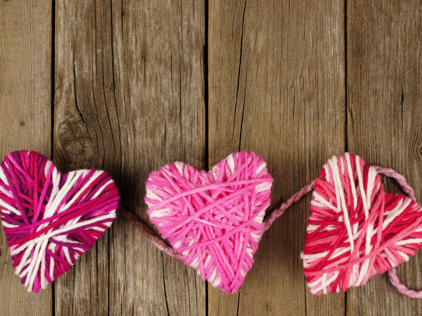 Сердца из ниток на деревянном столе