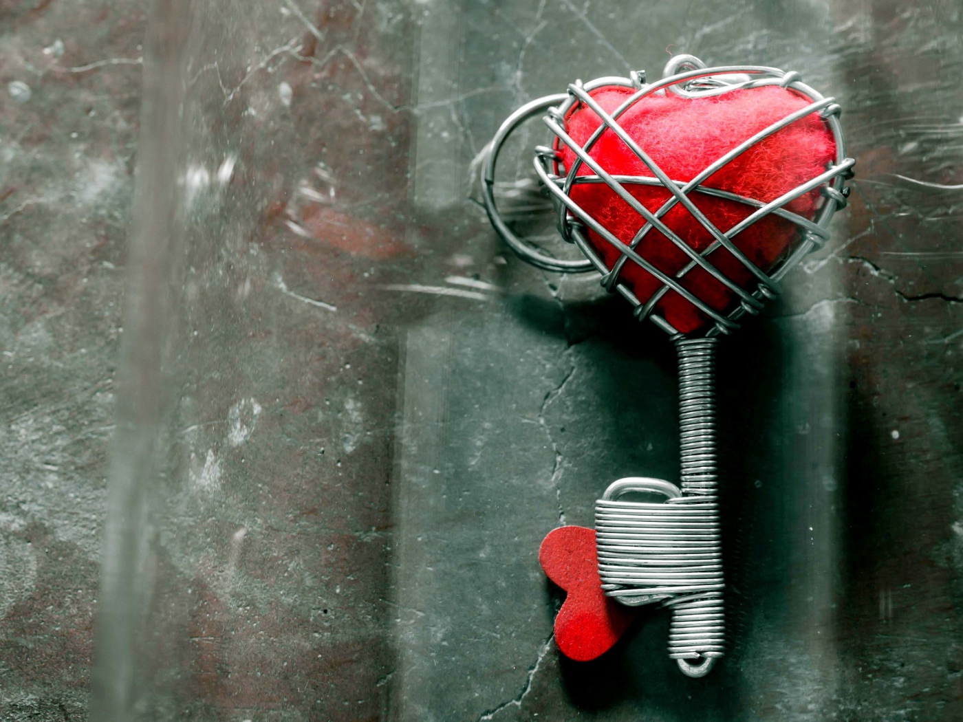 Ключ с красным сердцем на сером столе