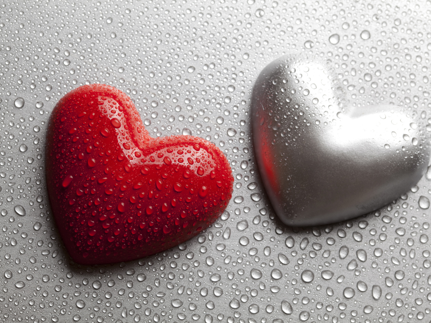 Красное и серое сердце на сером фоне в каплях воды