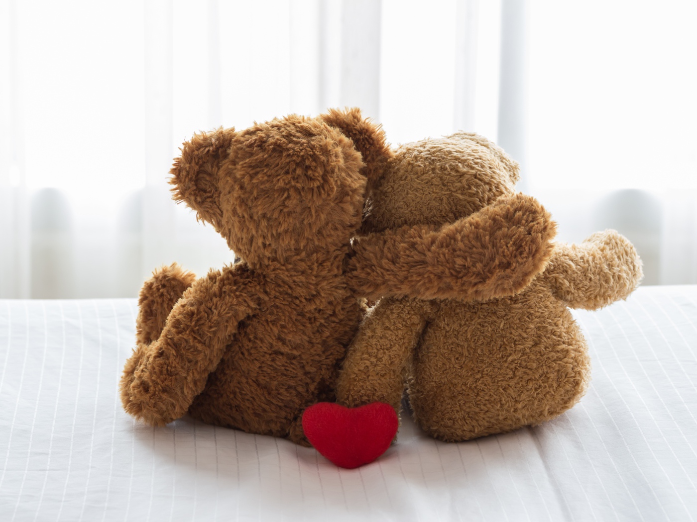 Два влюбленных плюшевых медвежонка на кровати