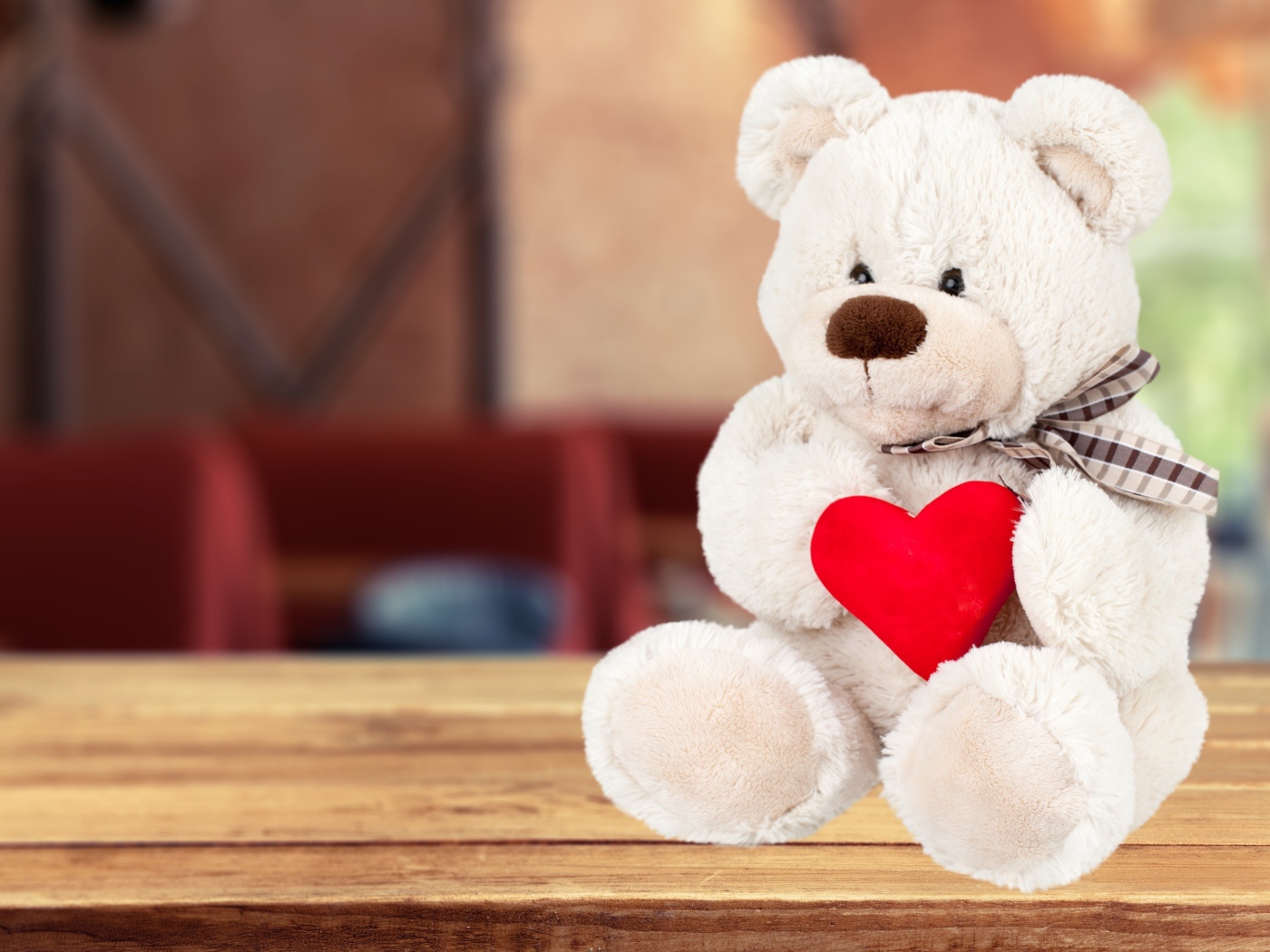 Белый плюшевый мишка с красным сердцем