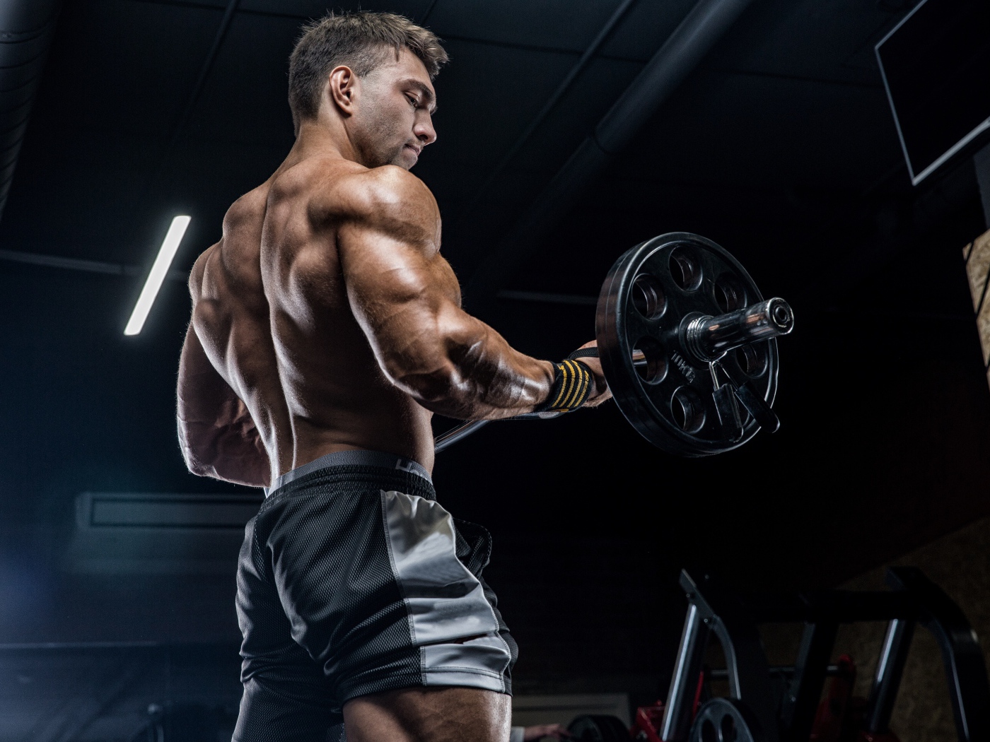 Спортивный накаченный мужчина со штангой в руках 