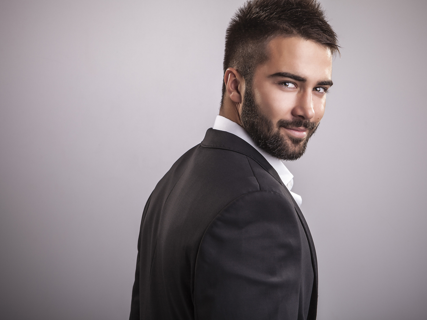 Красивый мужчина модель с бородой на сером фоне