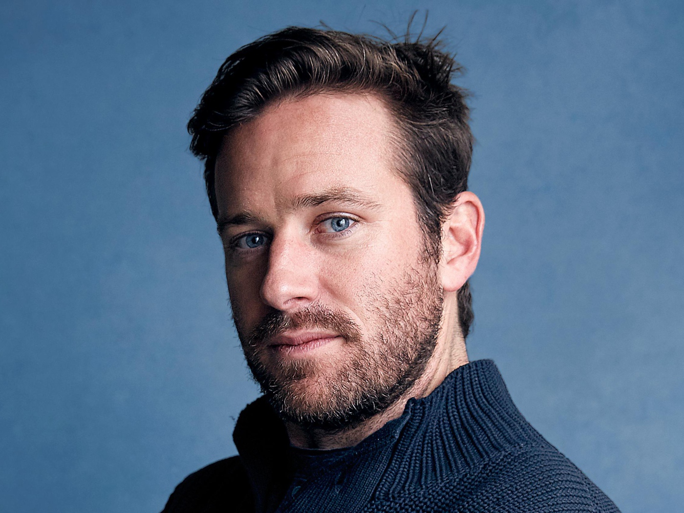 Актер Арми Хаммер на голубом фоне