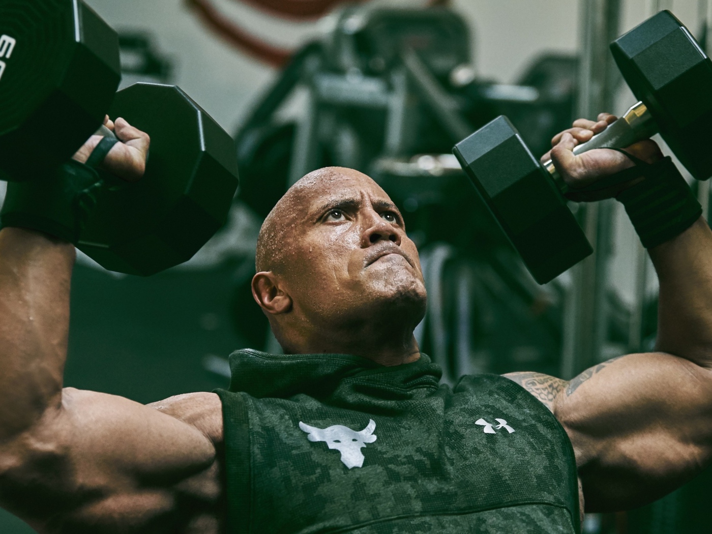 Американский актер, сильный мужчина Дуэйн Джонсон с гантелями в спортзале