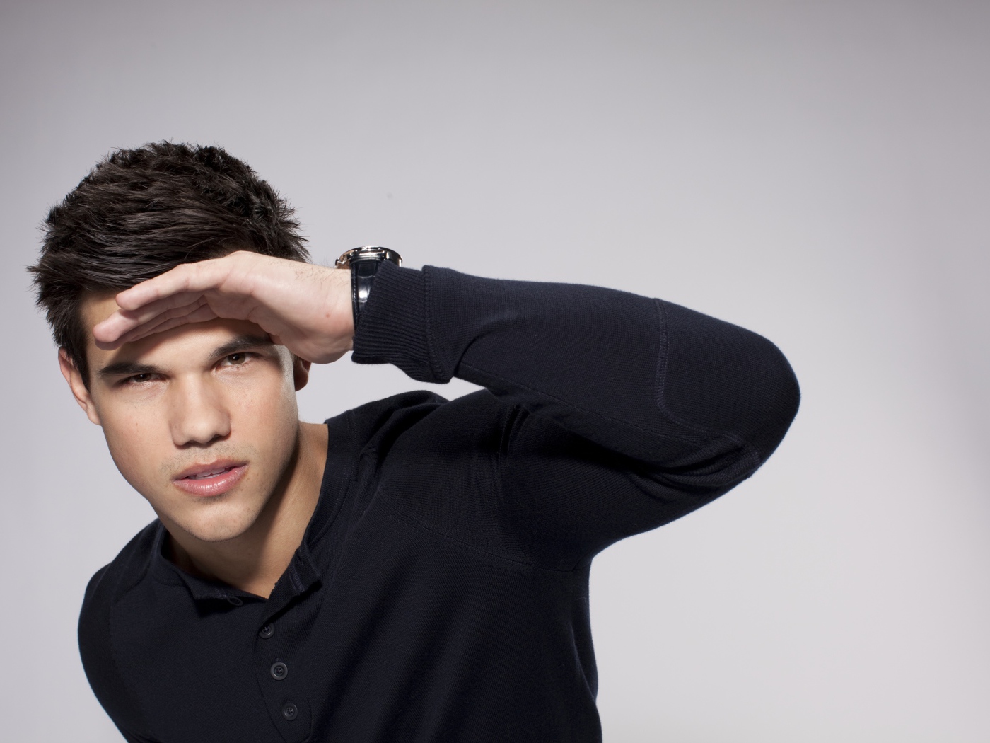 Красивый парень, актер Тейлор Лотнер на сером фоне