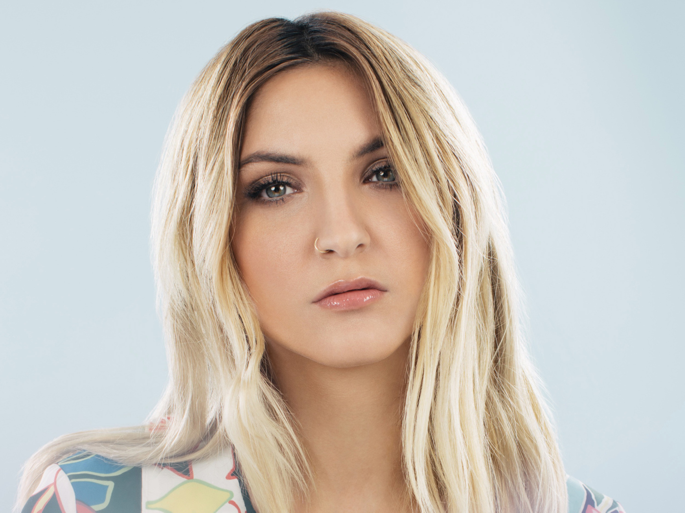 Красивая блондинка, певица Джулия Майклз на сером фоне