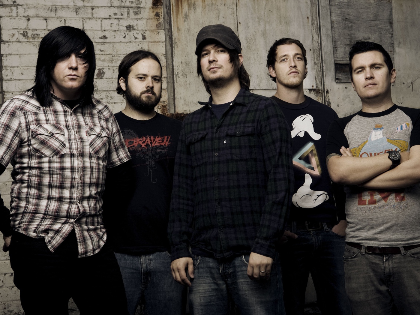 Музыкальная группа Funeral for a Friend стоят у старой стены