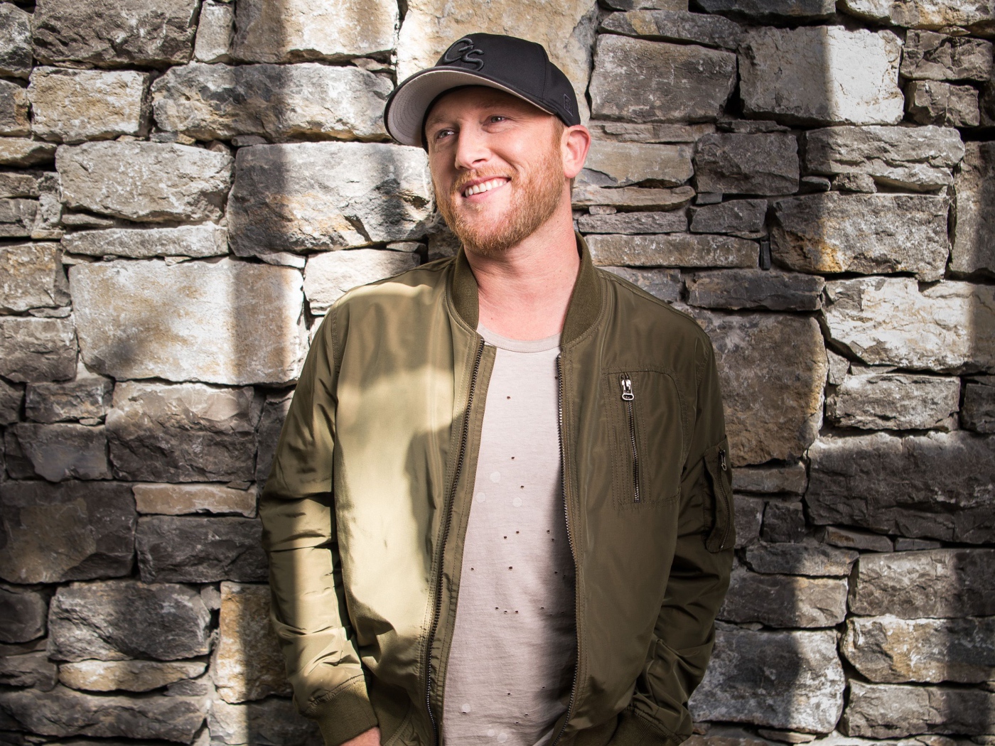 Музыкант Коул Суинделл в бейсболке у стены