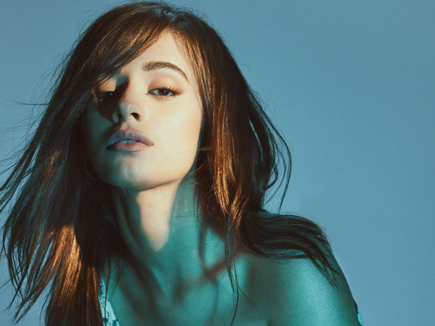 Молодая кареглазая певица Камила Кабельо на синем фоне