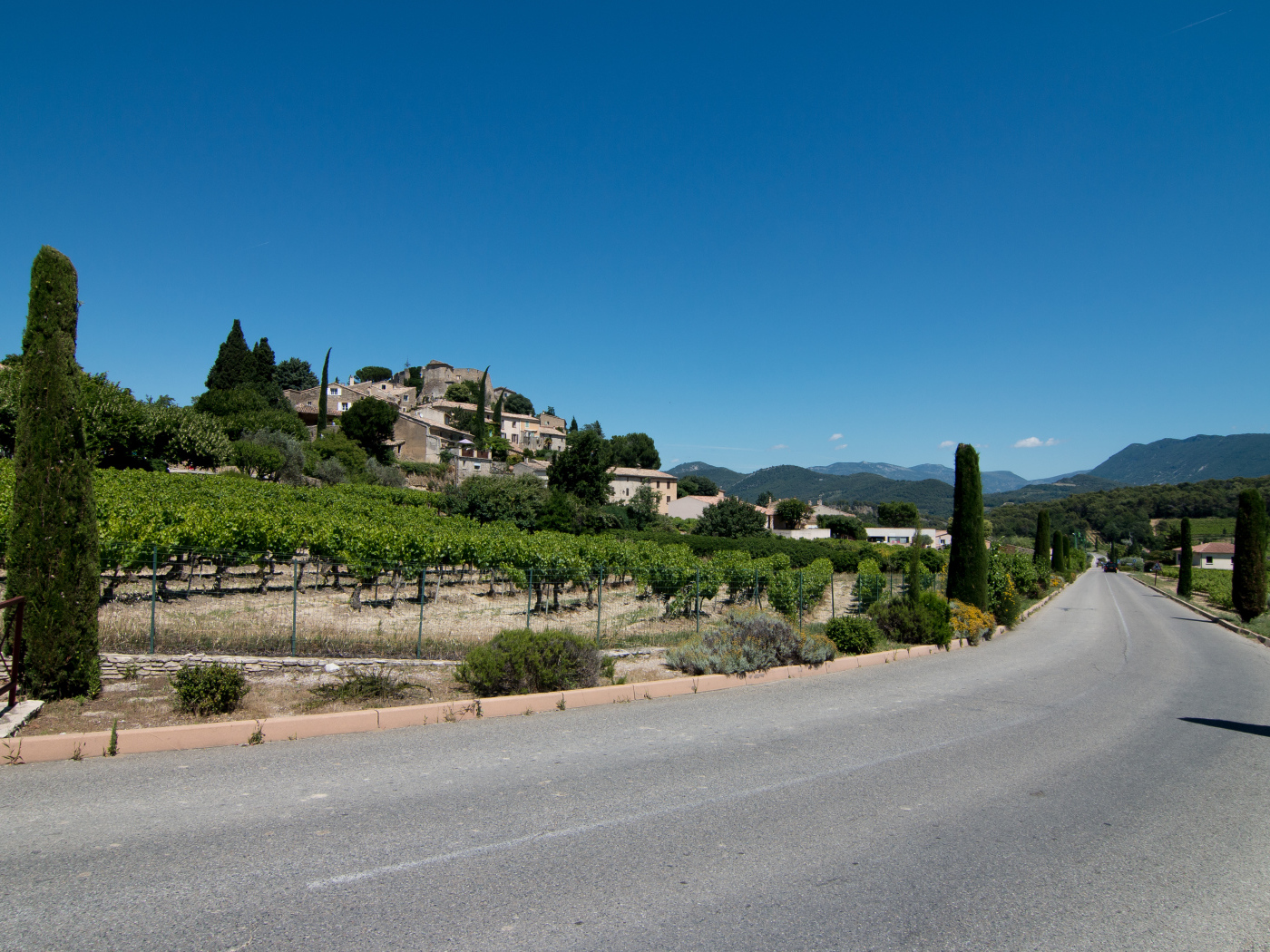 Асфальтовая дорога у большого дома под голубым небом