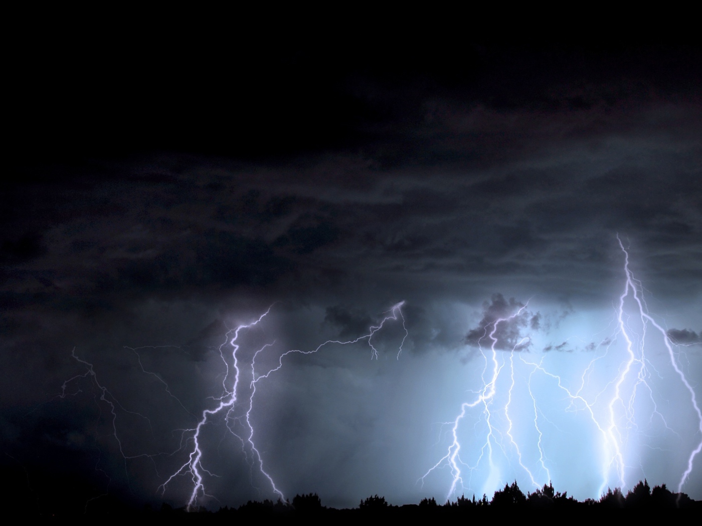 Яркие молнии в черном грозовом небе ночью