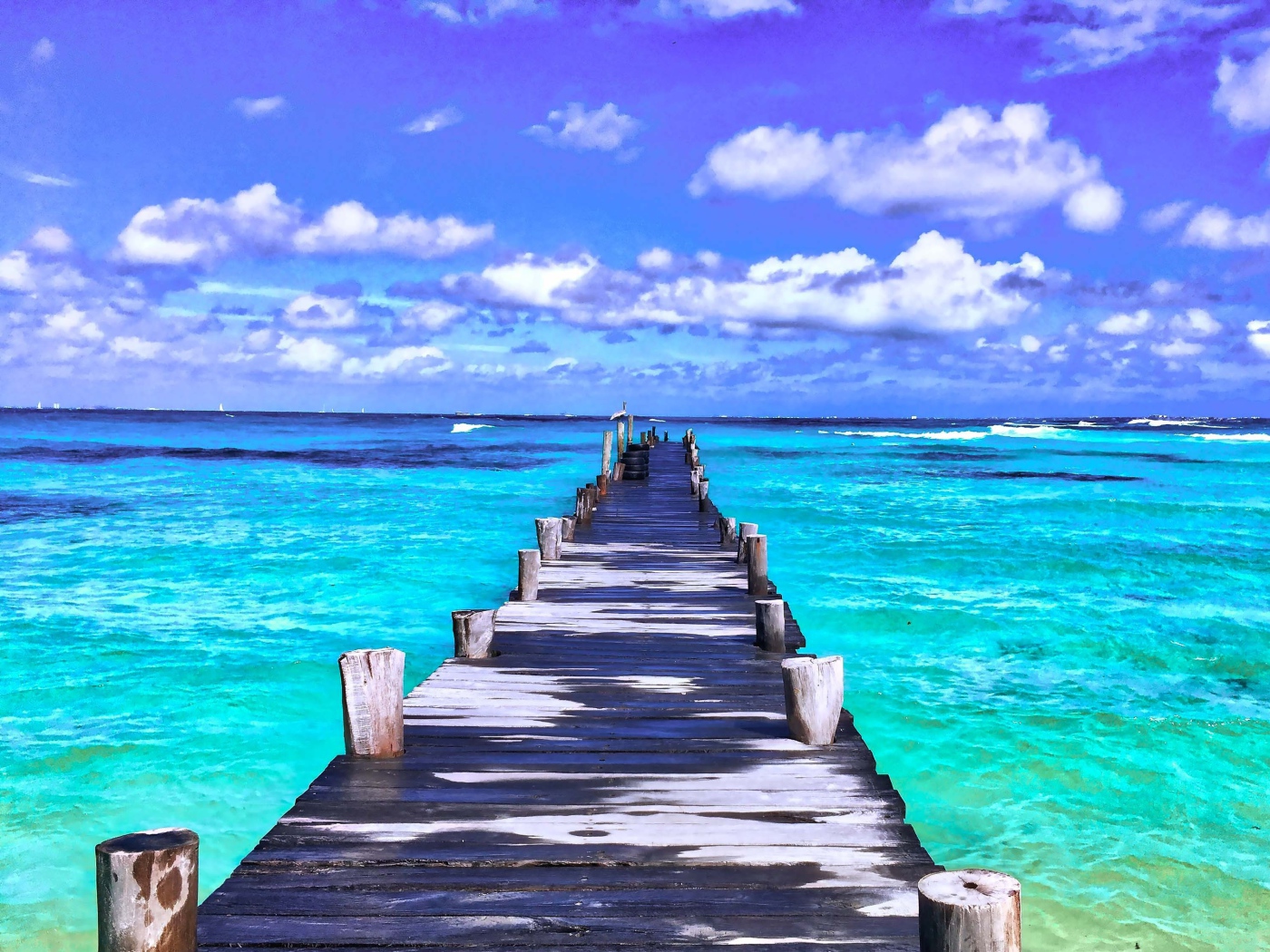 Деревянный мокрый пирс в голубом океане под красивым небом