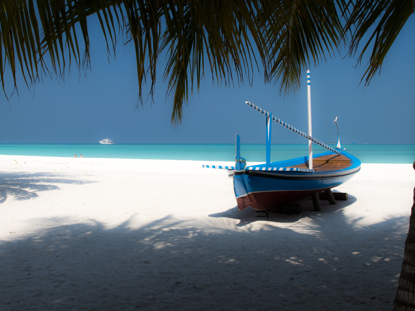 Лодка на белом песке у океана в тропиках