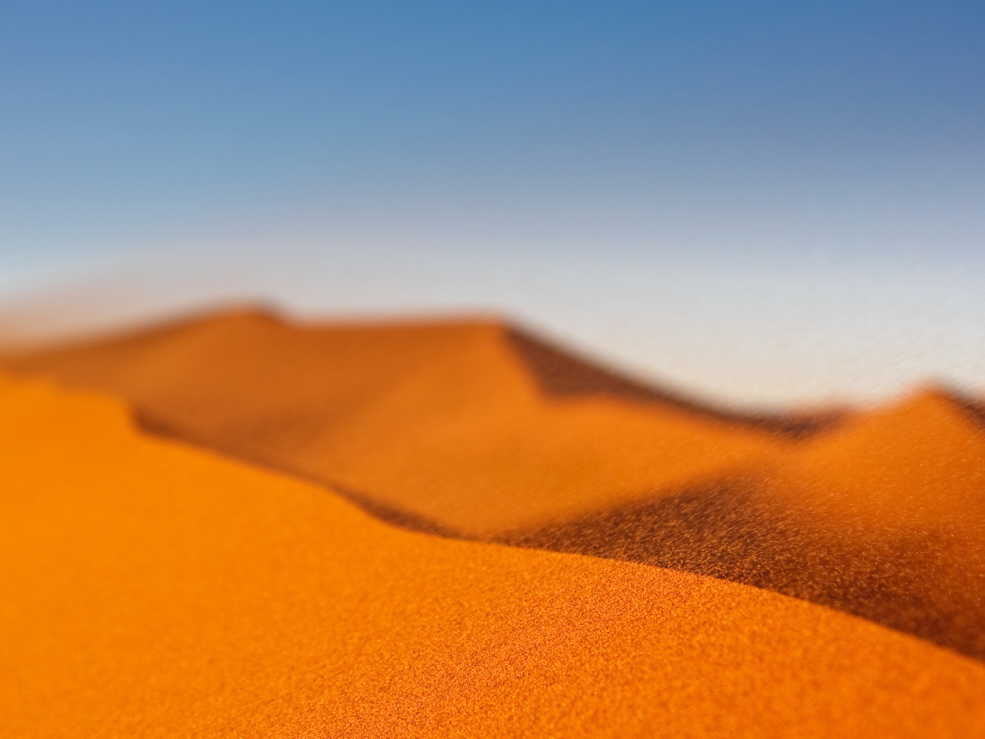 Желтый песок в пустыне под голубым небом