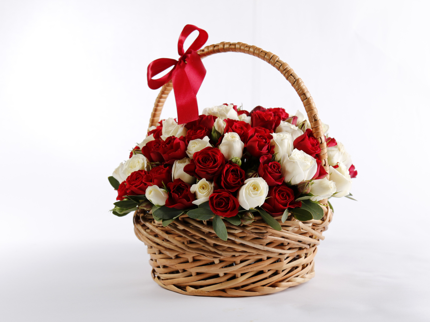 Большой букет роз в корзине в красным бантом на белом фоне