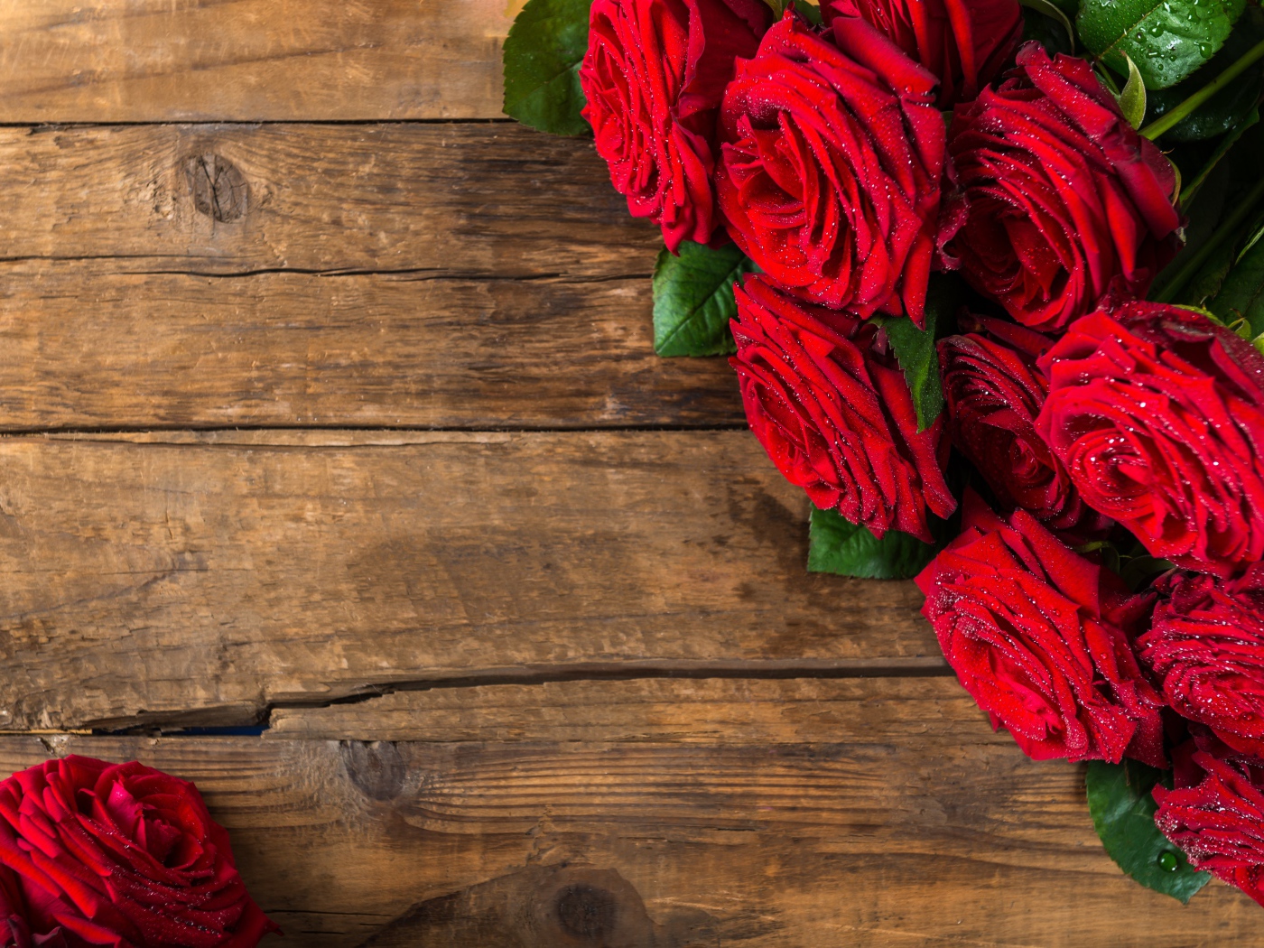 Красивый букет красных роз на деревянном фоне